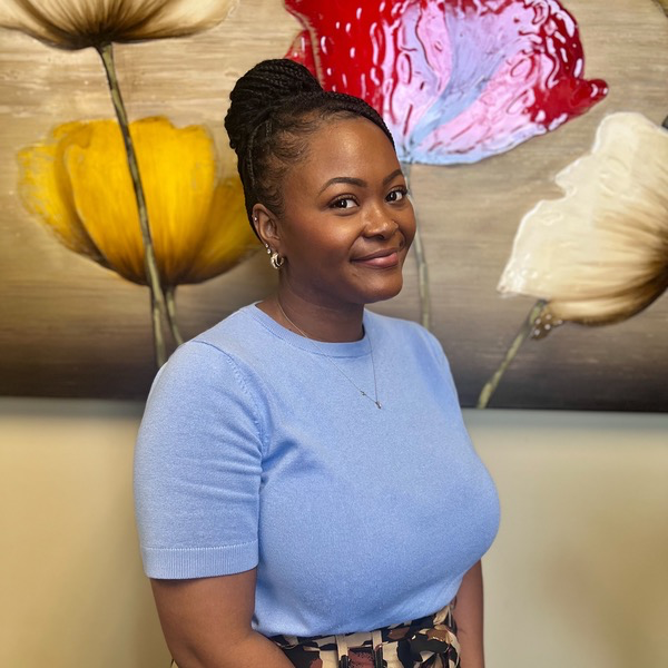 Tamika McIntosh in front of an image of red and yellow flowers
